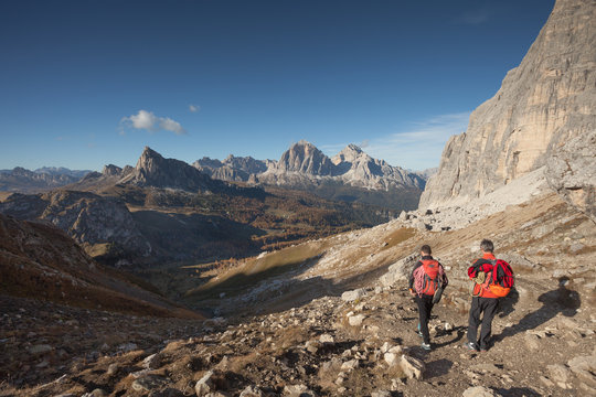 two climbers walking in the Mondeval area in Dolomites at evening after a climbing session