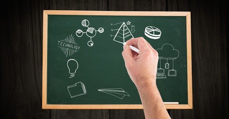 Cropped hand of man drawing on blackboard at wooden table