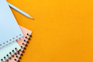 pencil and notebook on colorful paper background