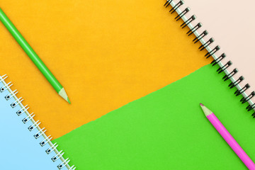 pencil and notebook on colorful paper background