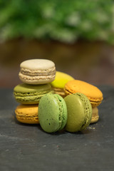 Macaroons on dark stone background.