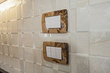 Closeup detail of light switches on a kitchen wall