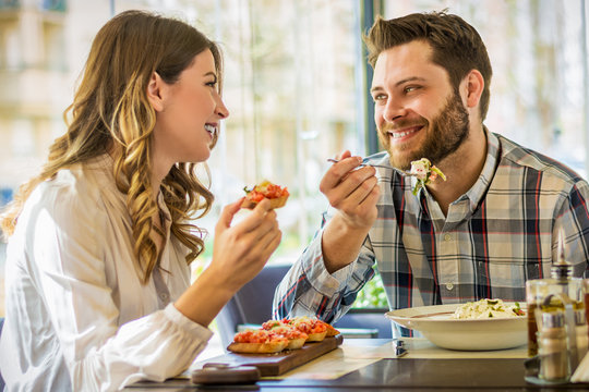 Couple enjoying lunch sitting at cafe table