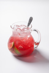 lemonade with strawberry, lemon and ice in a glass jug