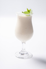 Delicious milkshake with a leaf of mint on top on a white background