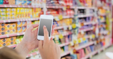 Cropped image of hand using smart phone in store