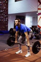 Fototapeta na wymiar Strong man lifting barbell as a part of crossfit exercise routine.