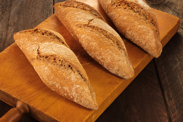Loaves of rye bread on rustic board