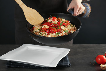 Woman putting chicken spaghetti onto plate