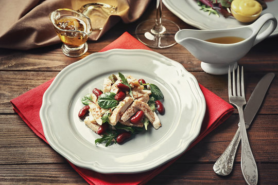 Tasty dish with chicken, beans, arugula and spinach on plate