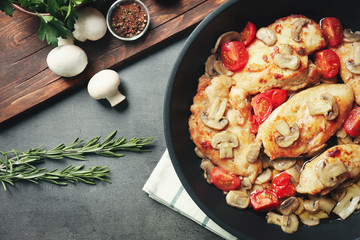 Frying pan with delicious chicken marsala on table