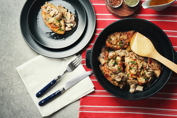 Frying pan with delicious chicken marsala on table