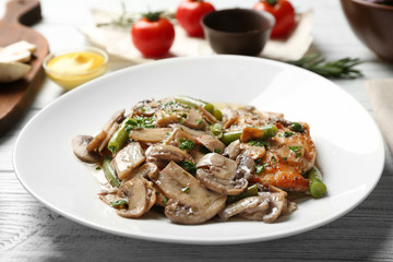 Chicken marsala with mushrooms and French beans on plate, closeup