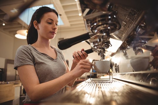 Female Barista Making Espresso In Coffee Shop