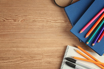Books and stationery on wooden background