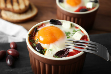 Baked egg with tomatoes and olives, closeup