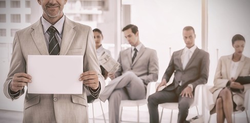 Smiling businessman holding blank notice