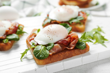 Tasty eggs Benedict on cutting board