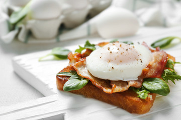 Tasty eggs Benedict on cutting board