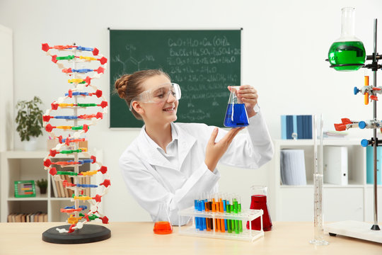 School girl sitting at table in chemistry class