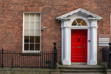 Fototapeta na wymiar Red door on a brick wall
