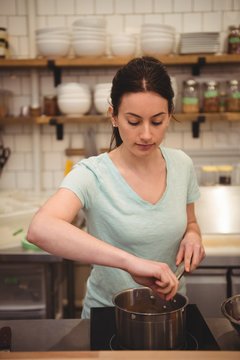 Female chef cooking food in commercial kitchen