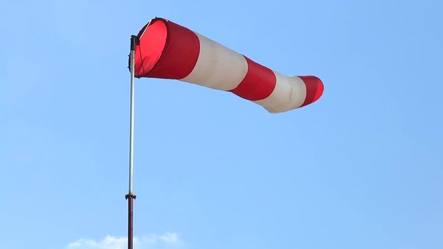 Cone-wind indicator against a blue sky. Rotation in motion