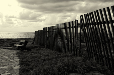 black and white image of broken wooden fence