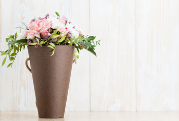  flowers in a cone box on a white wooden background