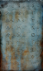 Lycian alphabet embossed on stone and exhibited in a park. There is also Latin alphabet equivalent near letters.