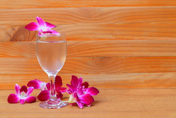 water glass cool with orchid purple  on wooden floor board with copy space add text