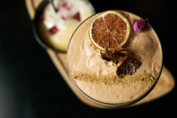 Close-up of Fresh alcoholic cocktail with lime, mint garnish and ice on black table and textured background. Foaming Alcoholic, non-alcoholic drink-beverage at the bar counter in the night club.