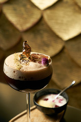 Close-up of Fresh alcoholic cocktail with lime, mint garnish and ice on black table and textured background. Foaming Alcoholic, non-alcoholic drink-beverage at the bar counter in the night club.