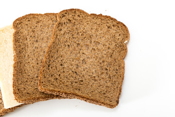 Whole grain sandwich bread slices with one white slice, on white background.