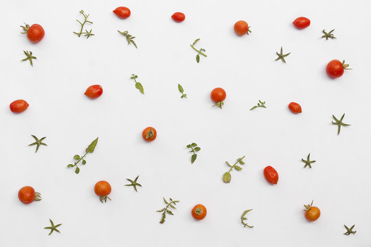 tomatoes and leaves pattern on white background. Flat lay.