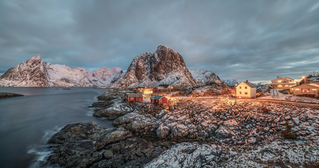 Fishing hut (rorbu) in the Hamnoy and Lilandstinden mountain peak at sunset - Reine, Lofoten...