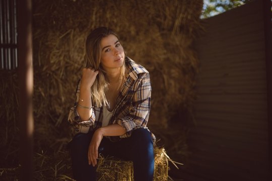 Portrait of beautiful woman sitting on hay