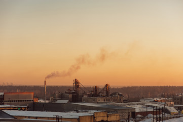 Industrial buildings at sunrise. Warehouses. Smoke from the pipe. Gradient.