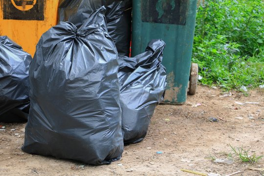 Pile black garbage bag roadside in the city