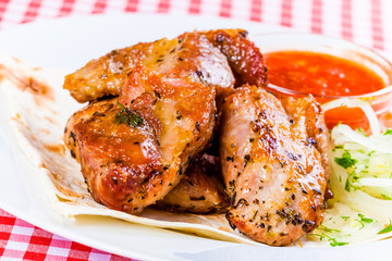 Grilled pork with tomato sauce and pita bread on white plate