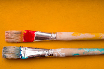 Fototapeta premium Paint brushes on the yellow background top view