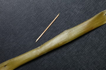 Banana leaf and small bamboo pin use for Thai traditional product packaging  to represent the basic idea of food containing material in the scene show the texture background of the leaf.