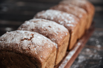 Bread with flour on dark wooden table