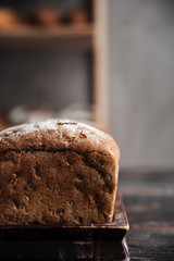 Bread with flour on dark wooden table
