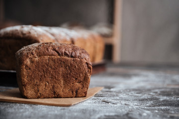 Bread with flour on dark wooden table