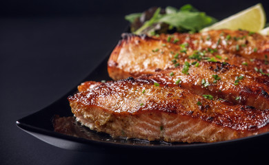 caramelized salmon steak on black background