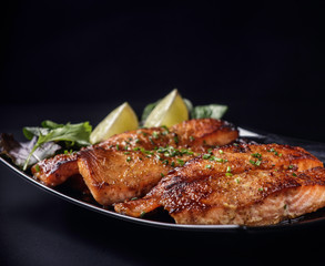 Caramelized salmon on black background