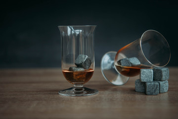 Stones for cooling whiskey and glases tulup on dark wooden background