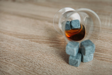 Stones for cooling whiskey and glases tulup on light wooden background