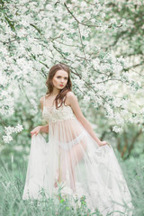 Fototapeta na wymiar Beauty girl in the lush garden of apple trees .